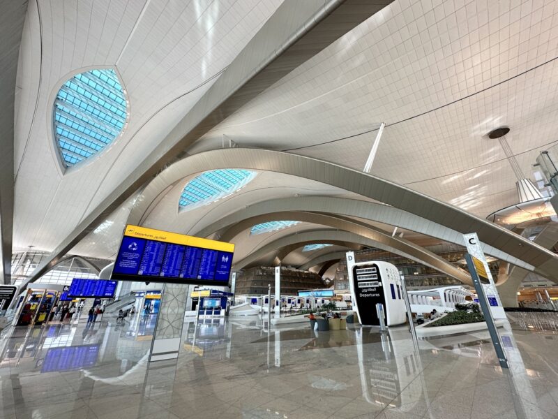 a large white building with blue signs and blue screens