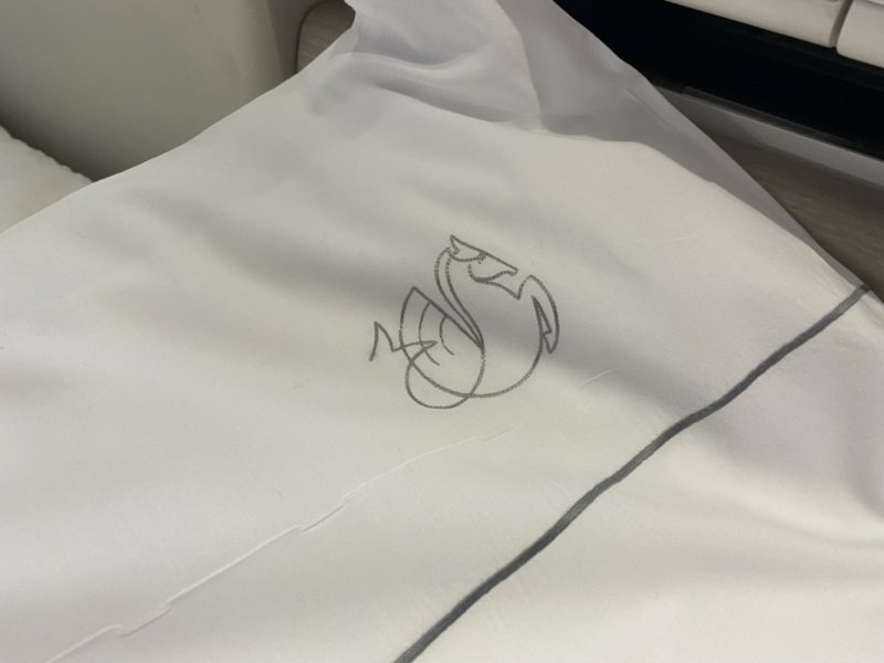 a white pillow with a swan design on it