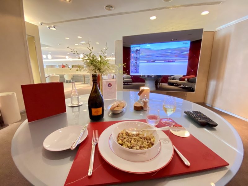 a table with a bowl of food and a bottle of wine