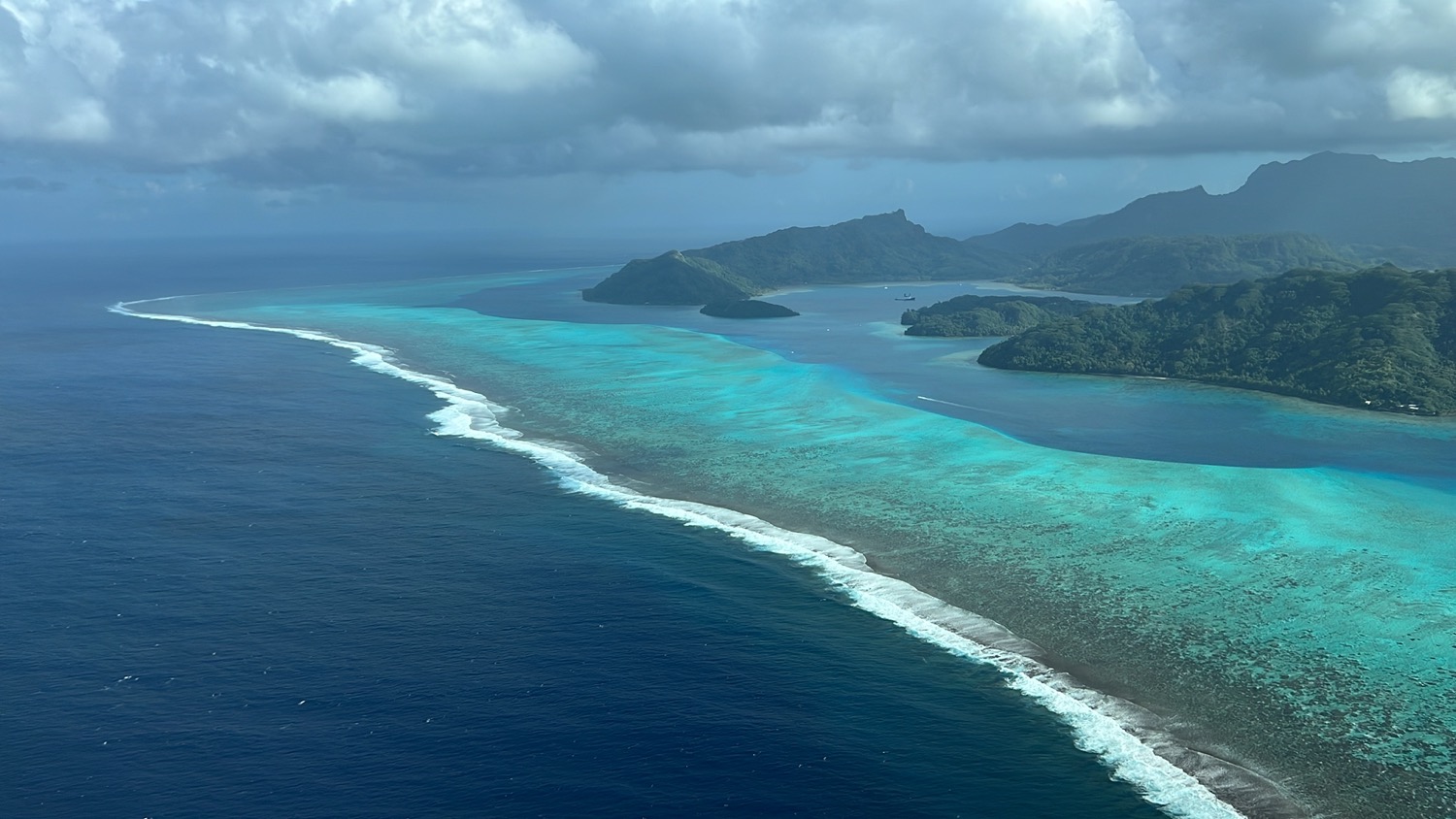 a blue ocean with islands and clouds