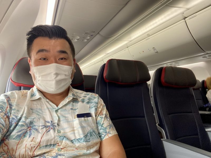 a man wearing a mask on an airplane