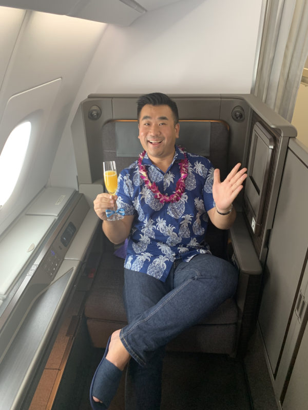 a man sitting in a chair holding a drink