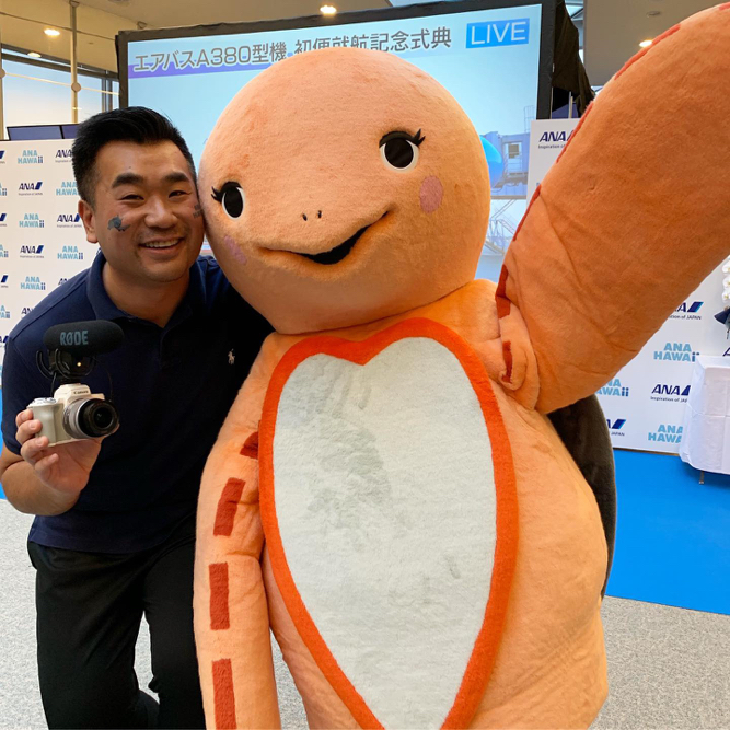 a man smiling with a large stuffed animal