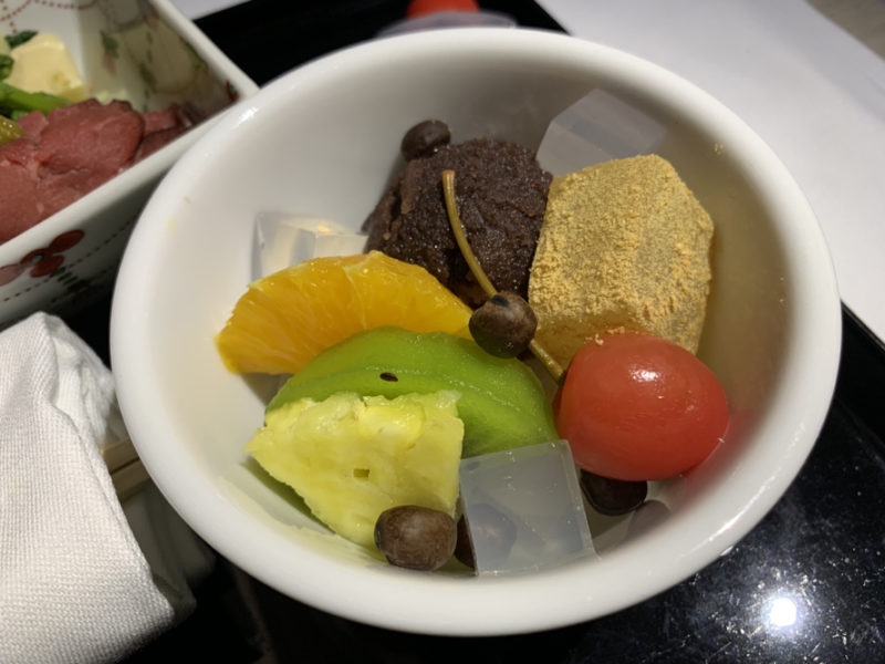 a bowl of fruit in a white bowl