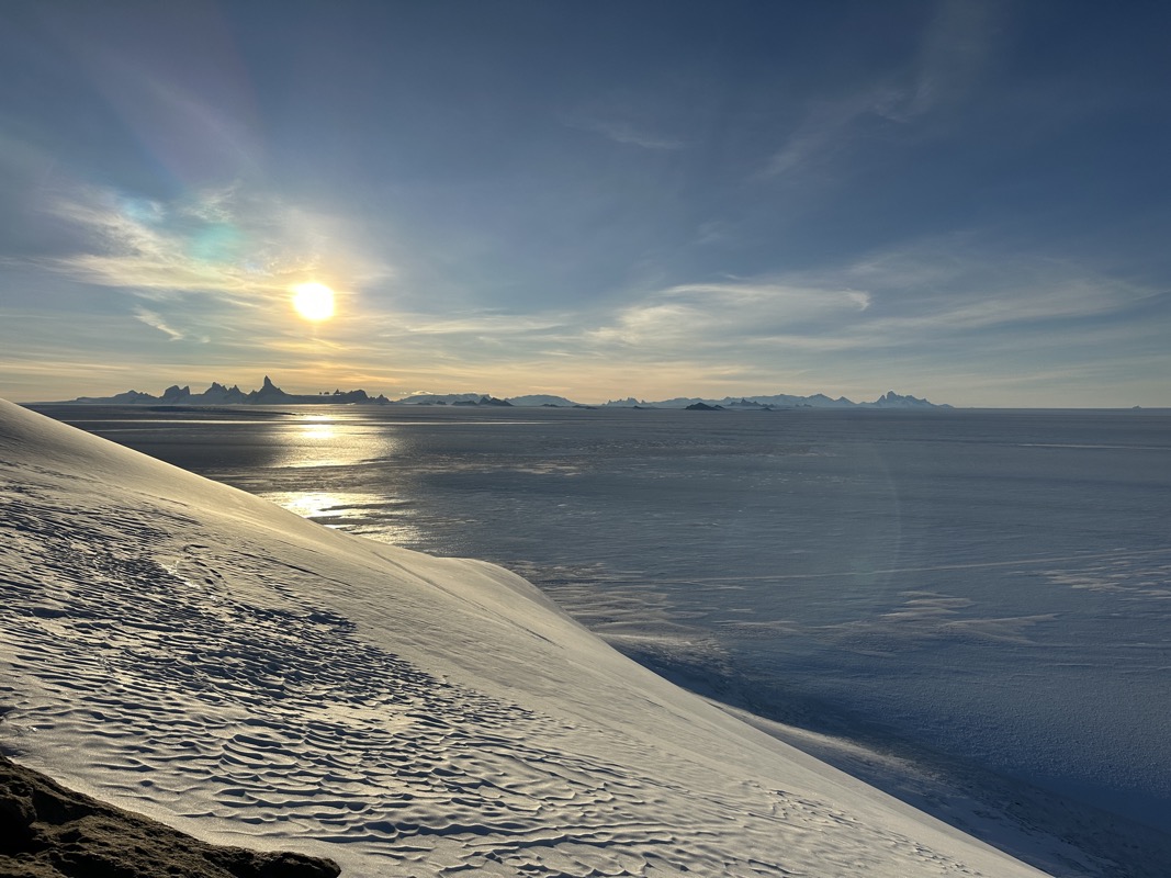 a snow covered hill next to a body of water