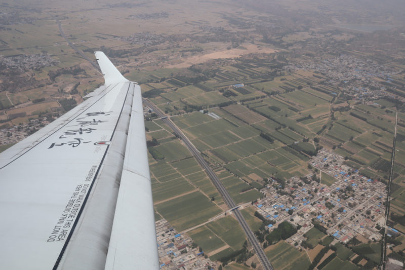 an airplane wing and a city