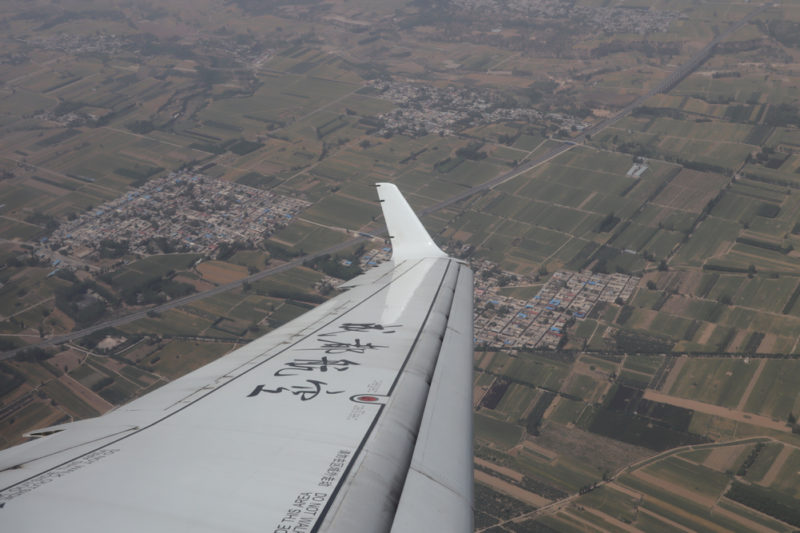 an wing of an airplane above a city