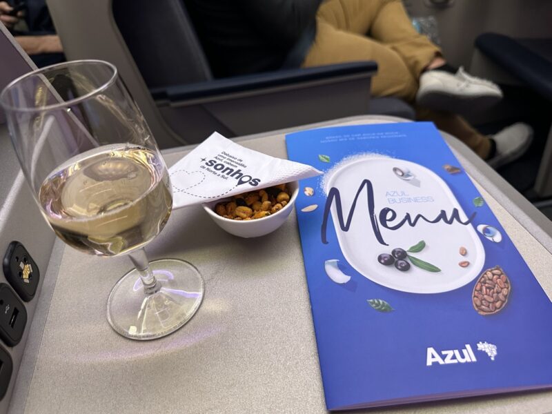 a glass of wine and a book on a table