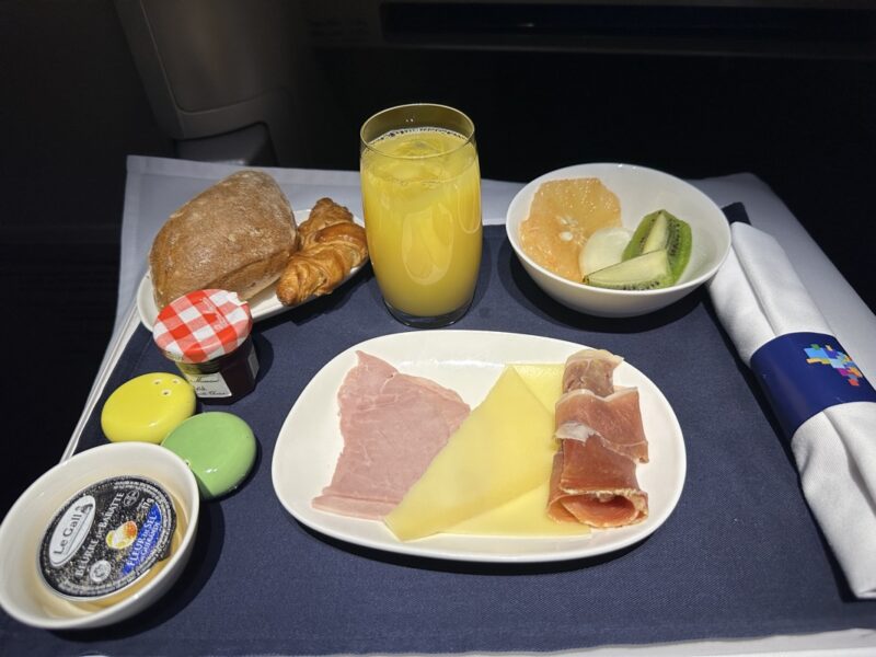 a plate of food and a glass of juice on a tray