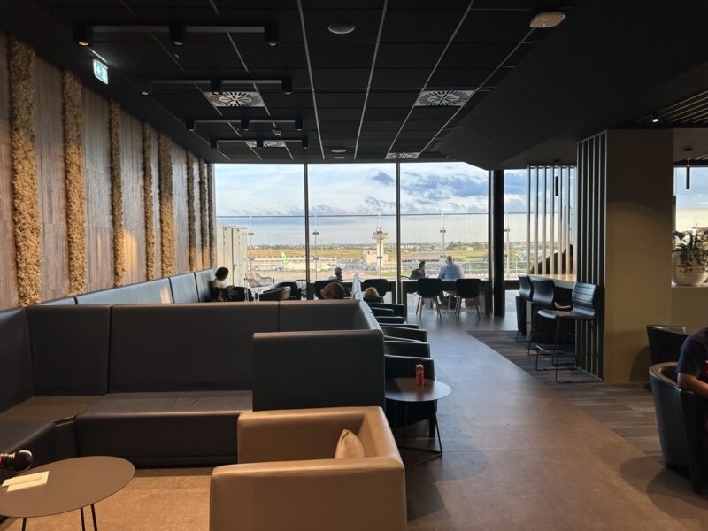 a room with a large window and a group of people sitting in chairs