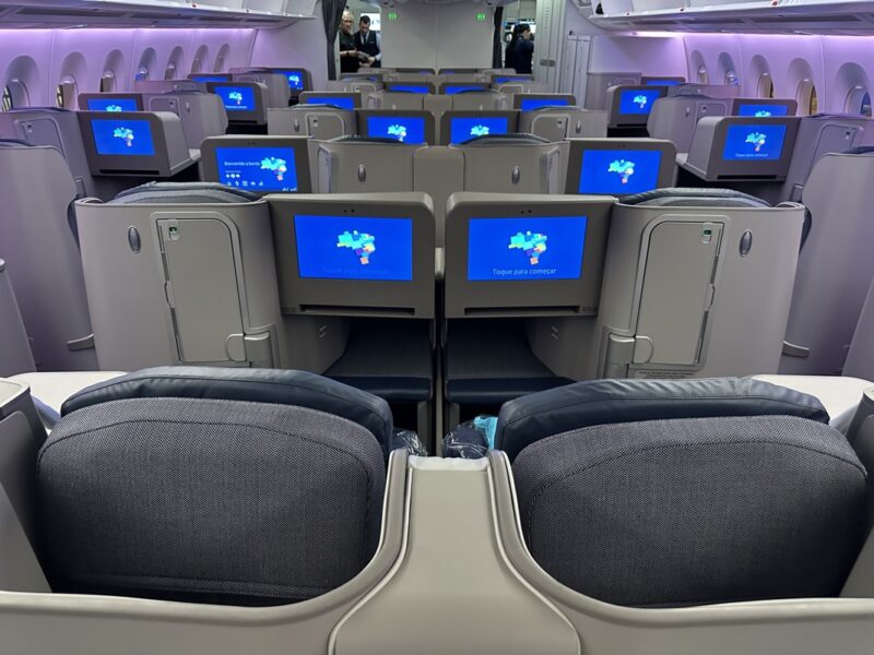 a row of seats with monitors on the back