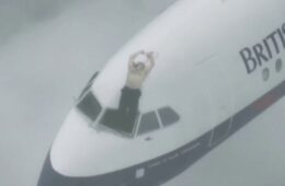 a man standing on the cockpit of an airplane