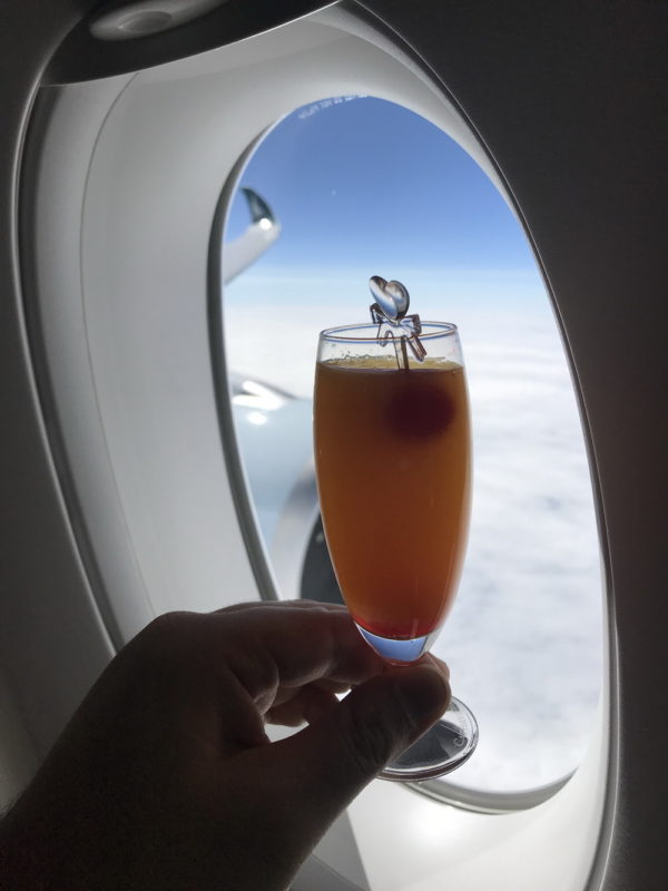 a hand holding a glass of orange liquid