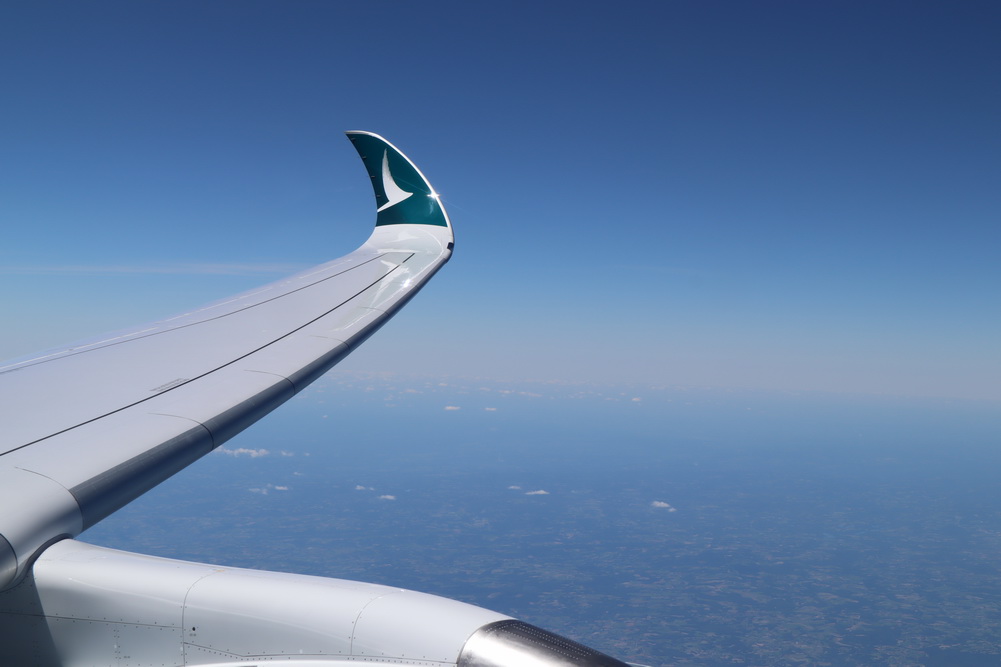 an airplane wing with a blue sky and clouds