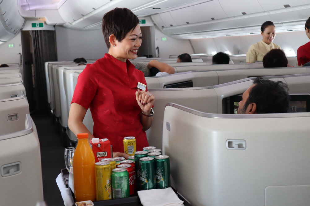 a woman standing in a chair with a tray of beverages