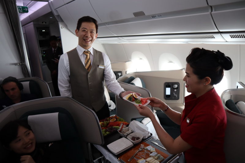 a man giving a plate of food to a woman