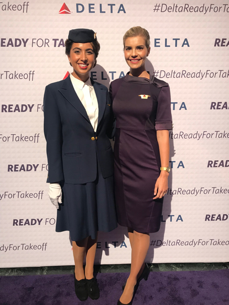 two women in uniform standing in front of a sign