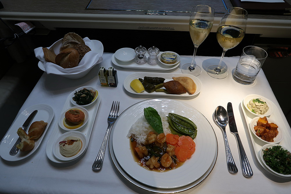 a table with plates of food and glasses of wine