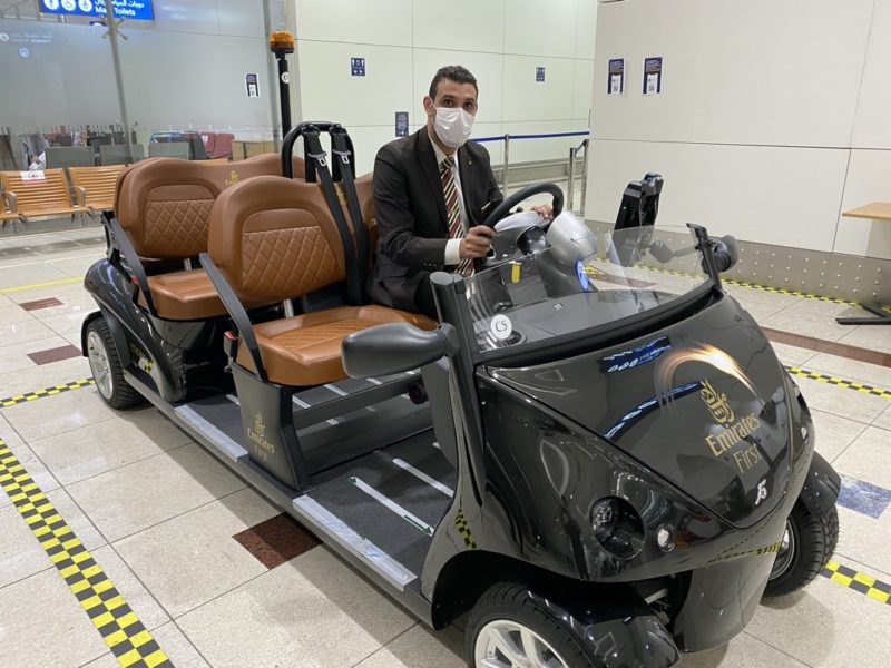 a man in a suit and tie wearing a face mask sitting on a black vehicle