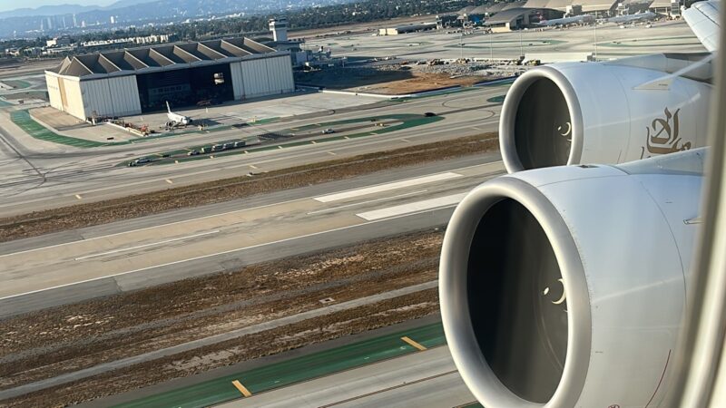 an airplane wing with a hangar in the background