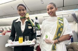 two women holding a tray and a bottle of wine