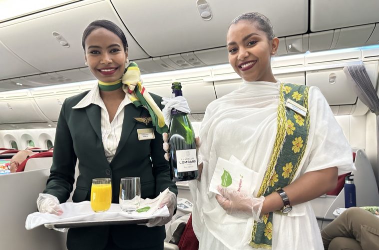 two women holding a tray and a bottle of wine