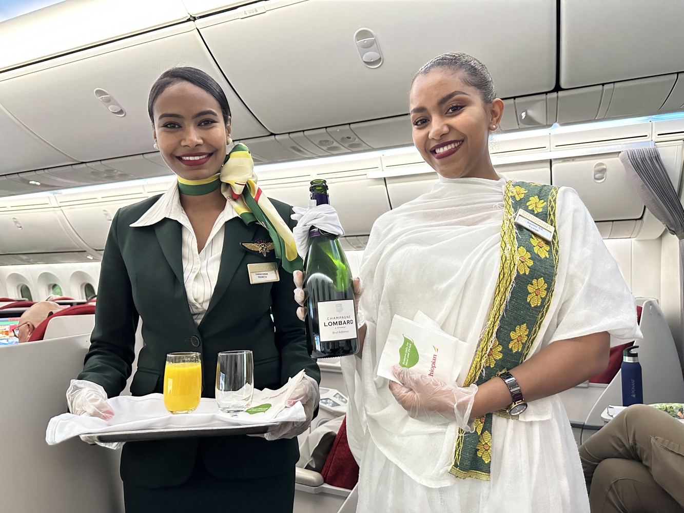 two women holding a tray and a bottle of wine