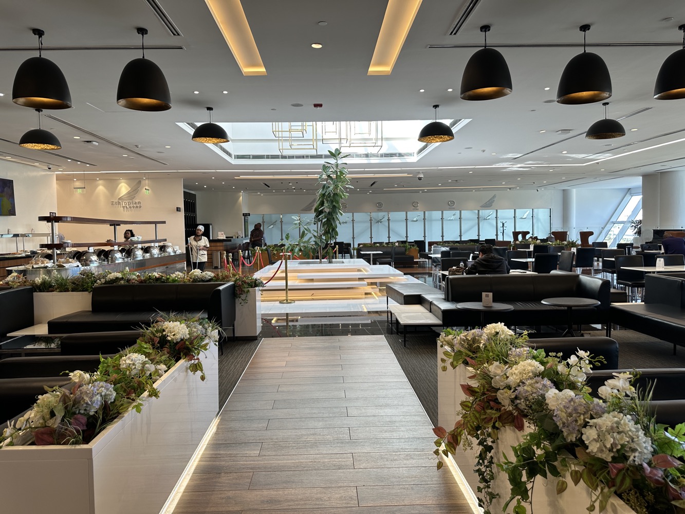 a room with a large white and black planter with flowers