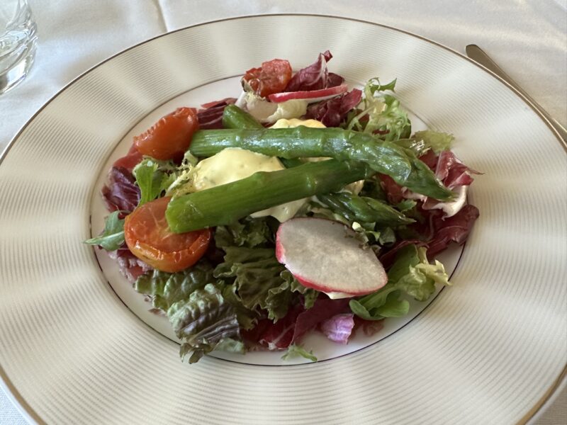 a plate of salad with asparagus and tomatoes