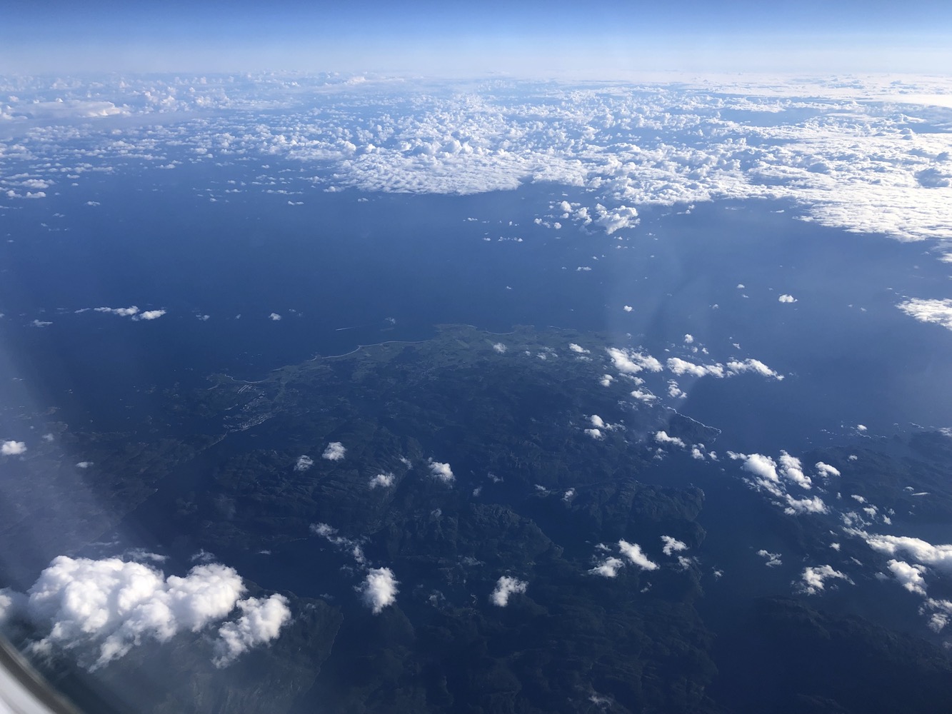 aerial view of clouds and land from an airplane