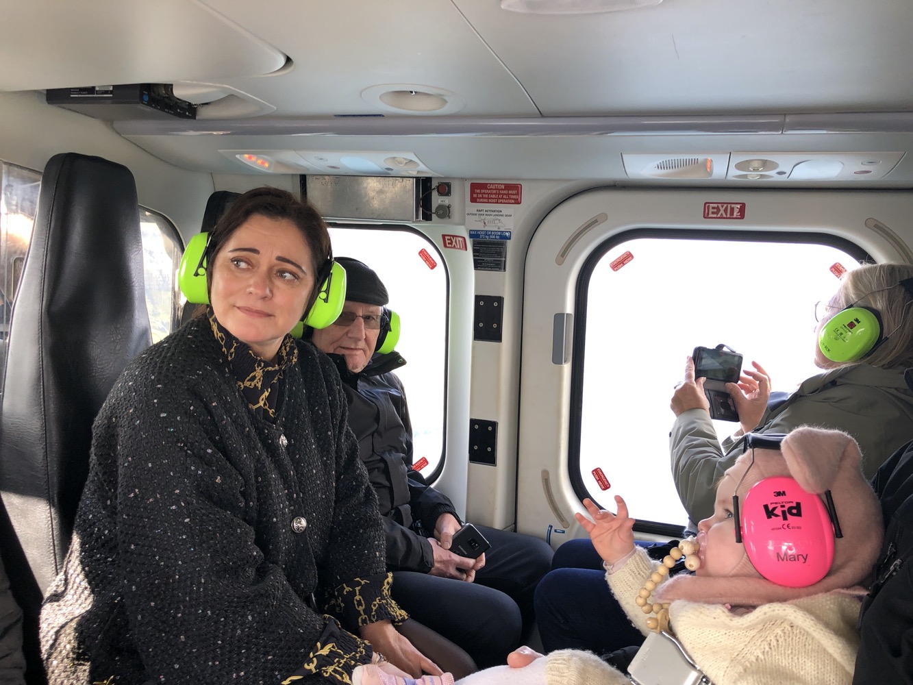 a woman with green headphones and a baby in a vehicle