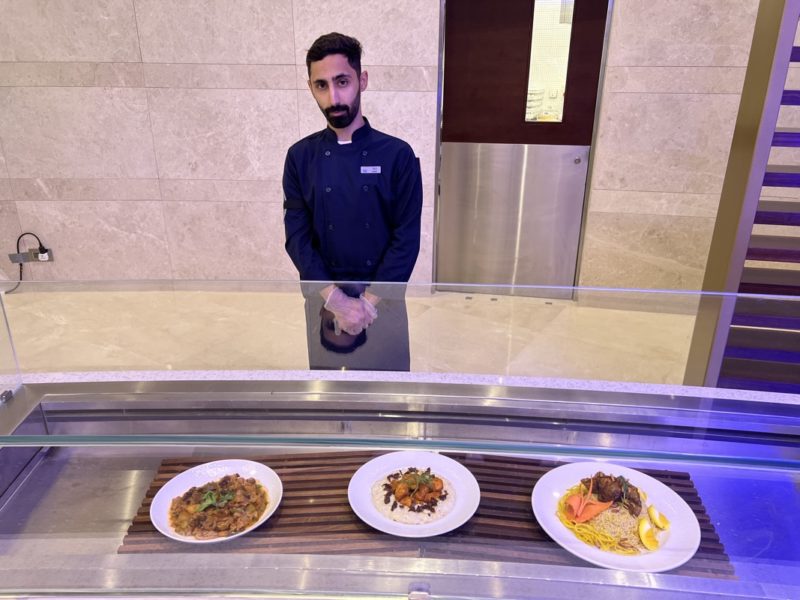 a man standing in front of a glass display of food