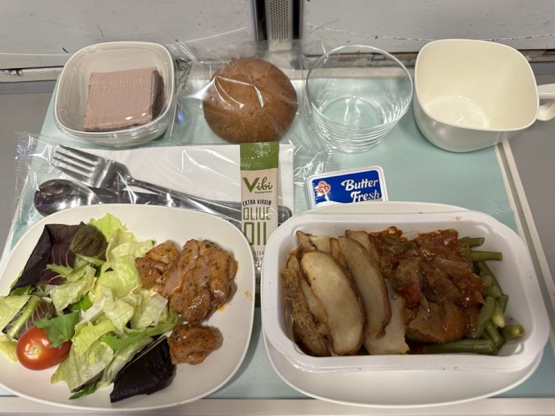 food in a tray with a salad and a fork