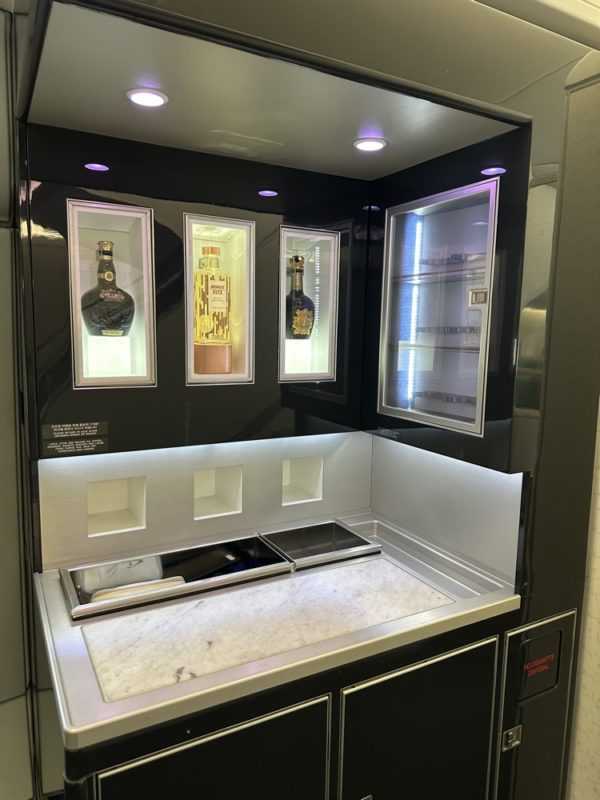 a black and silver bar with shelves and bottles of liquor