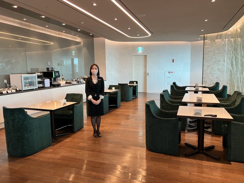 a woman standing in a room with tables and chairs