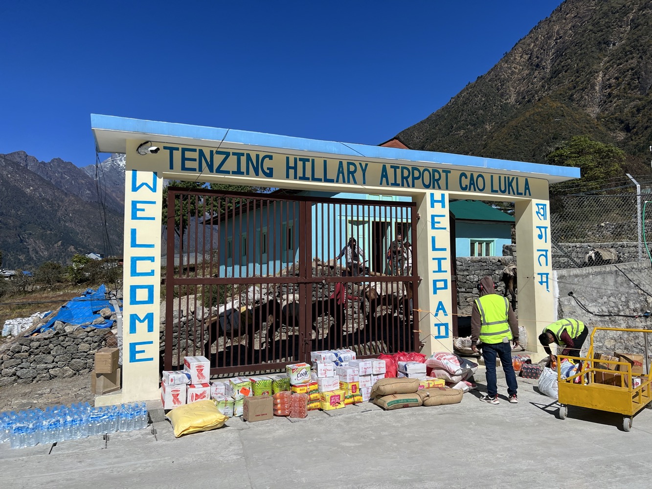 a man standing next to a gate with a sign