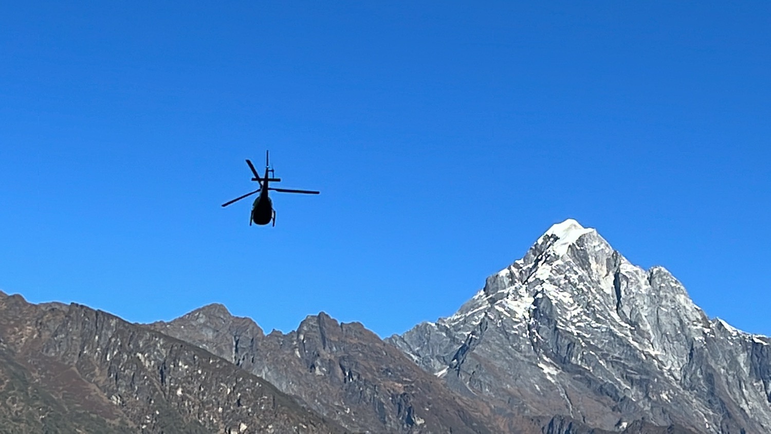 a helicopter flying over a mountain