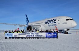 a group of people standing in front of a plane