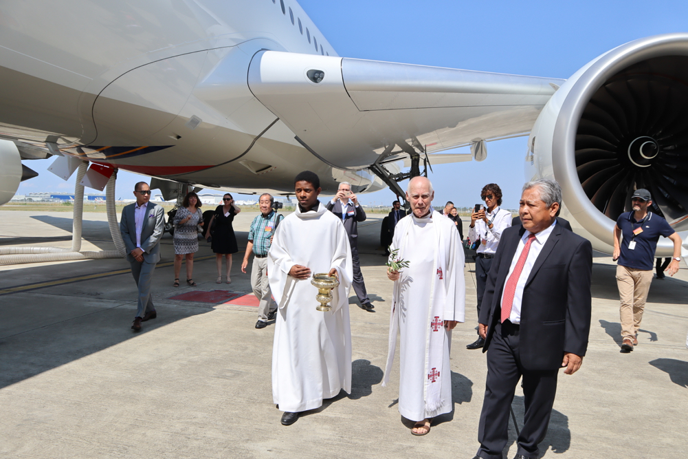 a group of people walking in front of an airplane