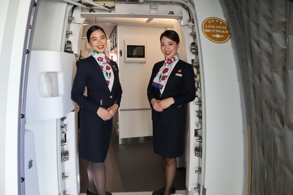 two women in flight uniforms standing in a doorway