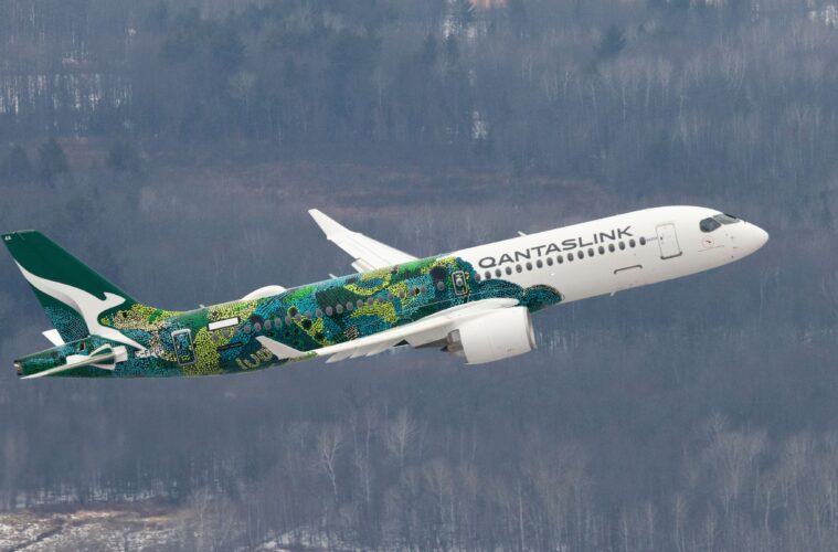 a white and green airplane flying in the sky