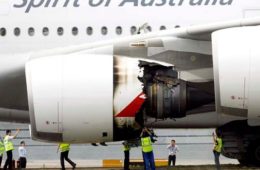 a group of people standing next to an airplane engine