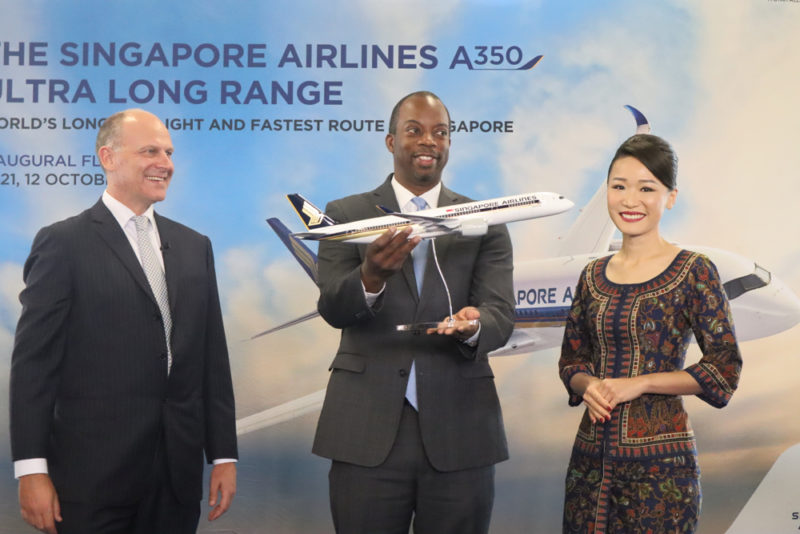 a group of people standing next to a model airplane