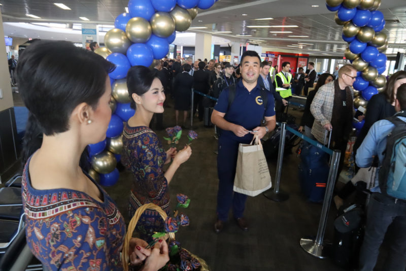 a group of people in a room with blue and gold balloons