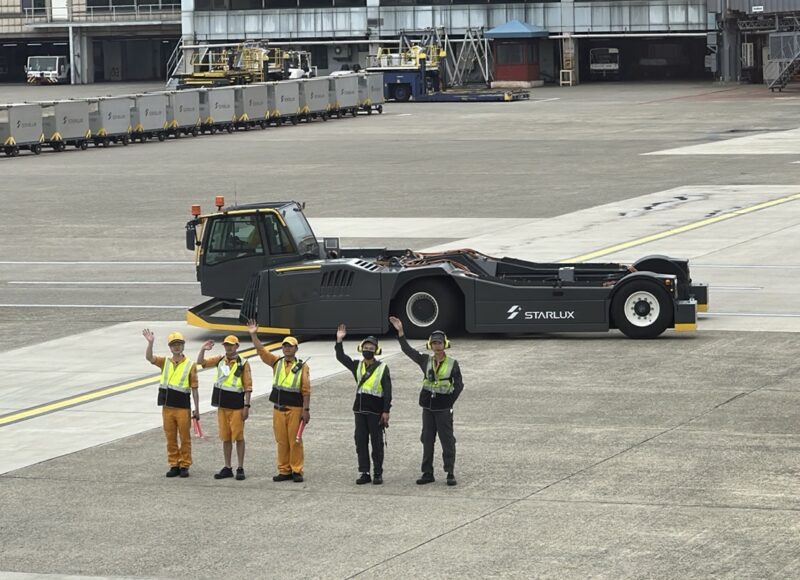 a group of people standing in front of a large vehicle