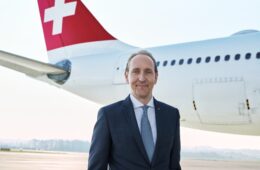 a man in a suit standing in front of a plane