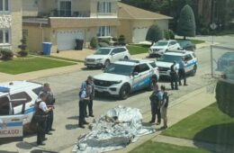 a group of police officers standing in front of a body of a body