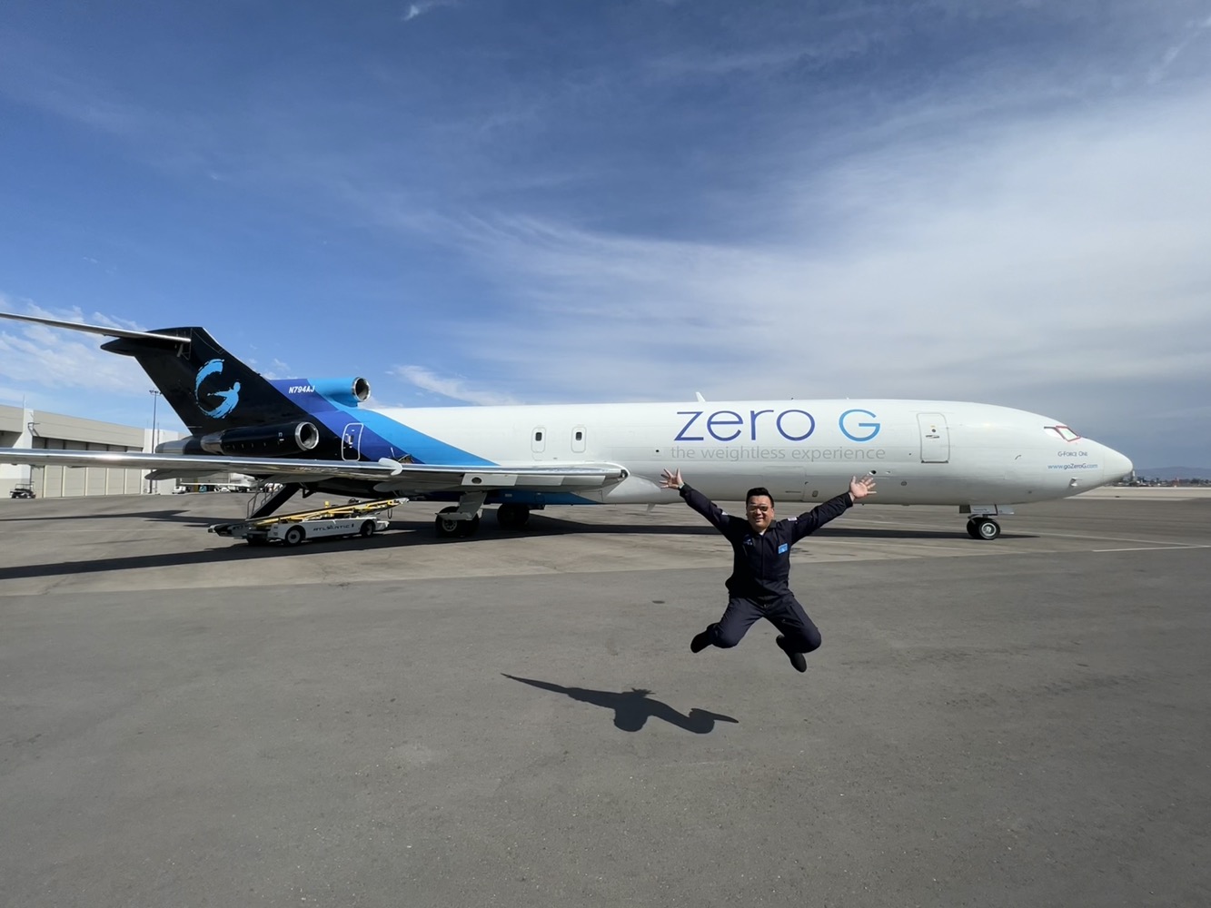 a man jumping in the air with a plane in the background